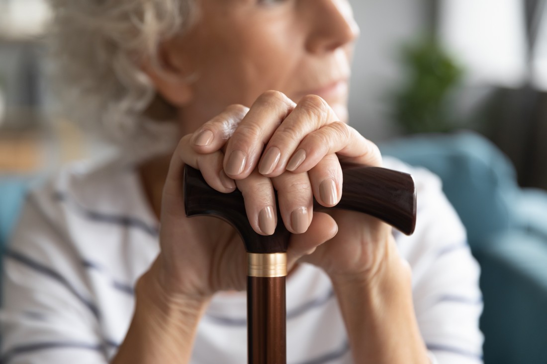 Close-up of an older woman holding a cane